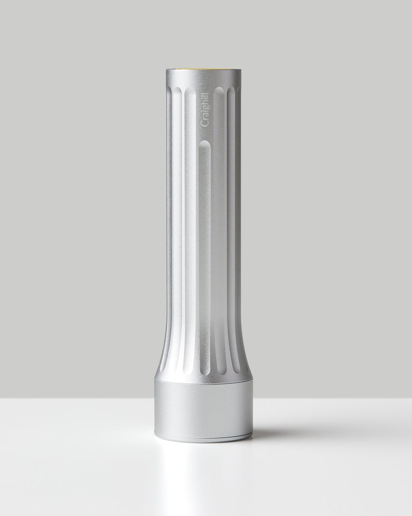 Silver flashlight with vertical ridges and flat base, cylindrical body