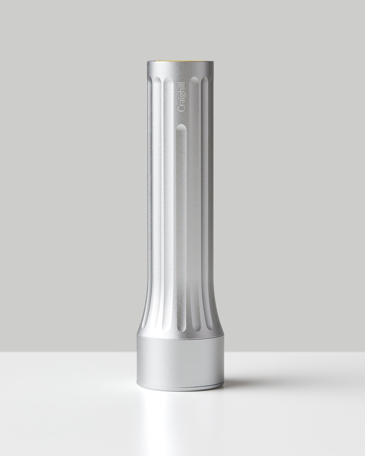 Silver flashlight with vertical ridges and flat base, cylindrical body