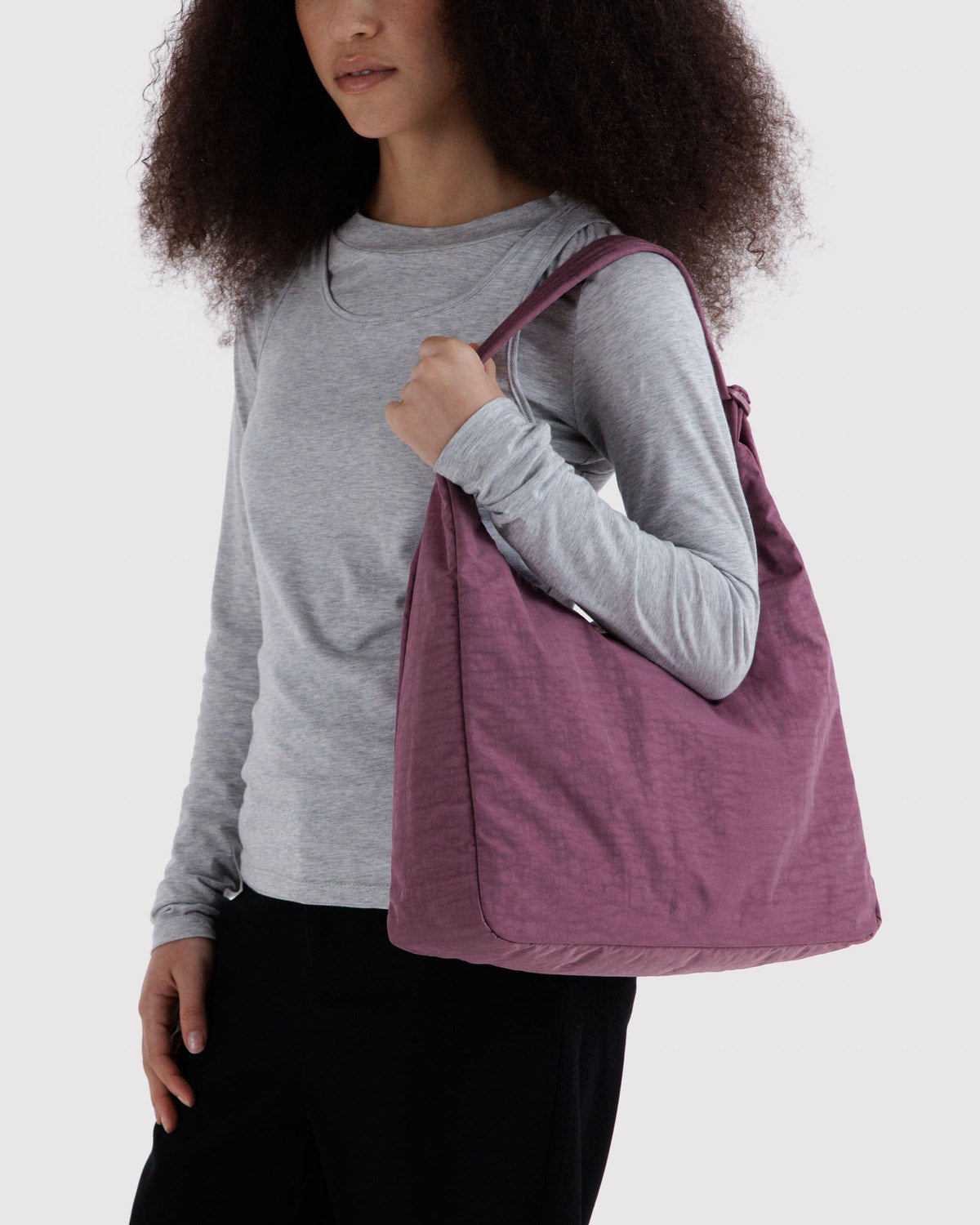 Plum purple nylon shoulder bag worn on the shoulder.