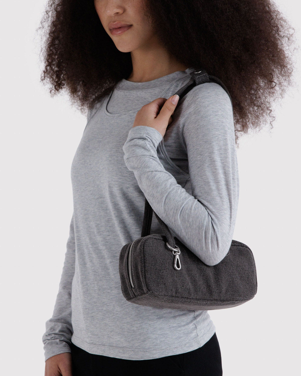 Washed black denim bowler bag held by a person with two top handles
