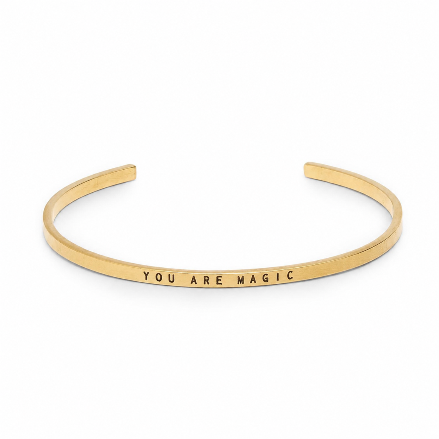 Narrow thin gold cuff bracelet stamped with “YOU ARE MAGIC”