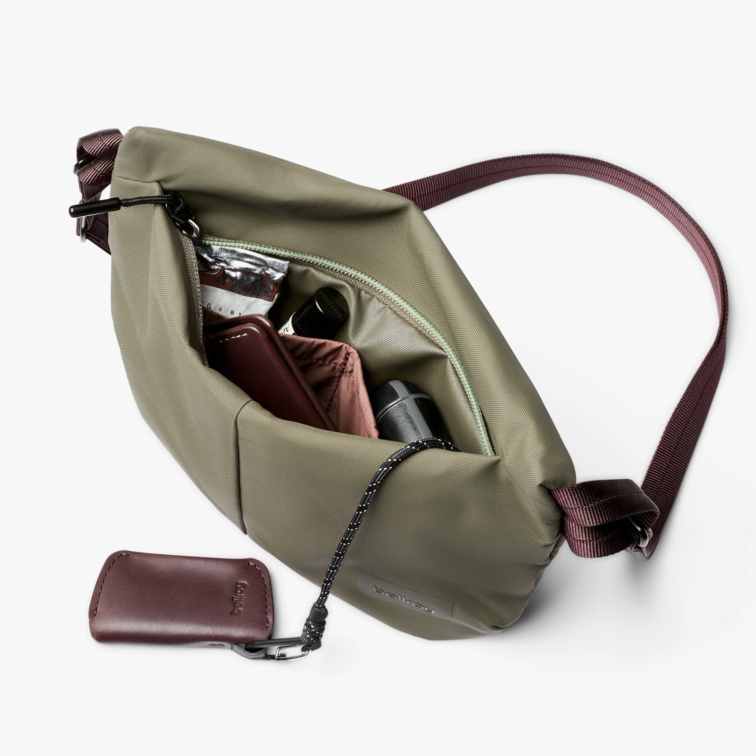 Crossbody bag in olive green with zip opening, interior organizer pockets, burgundy accents