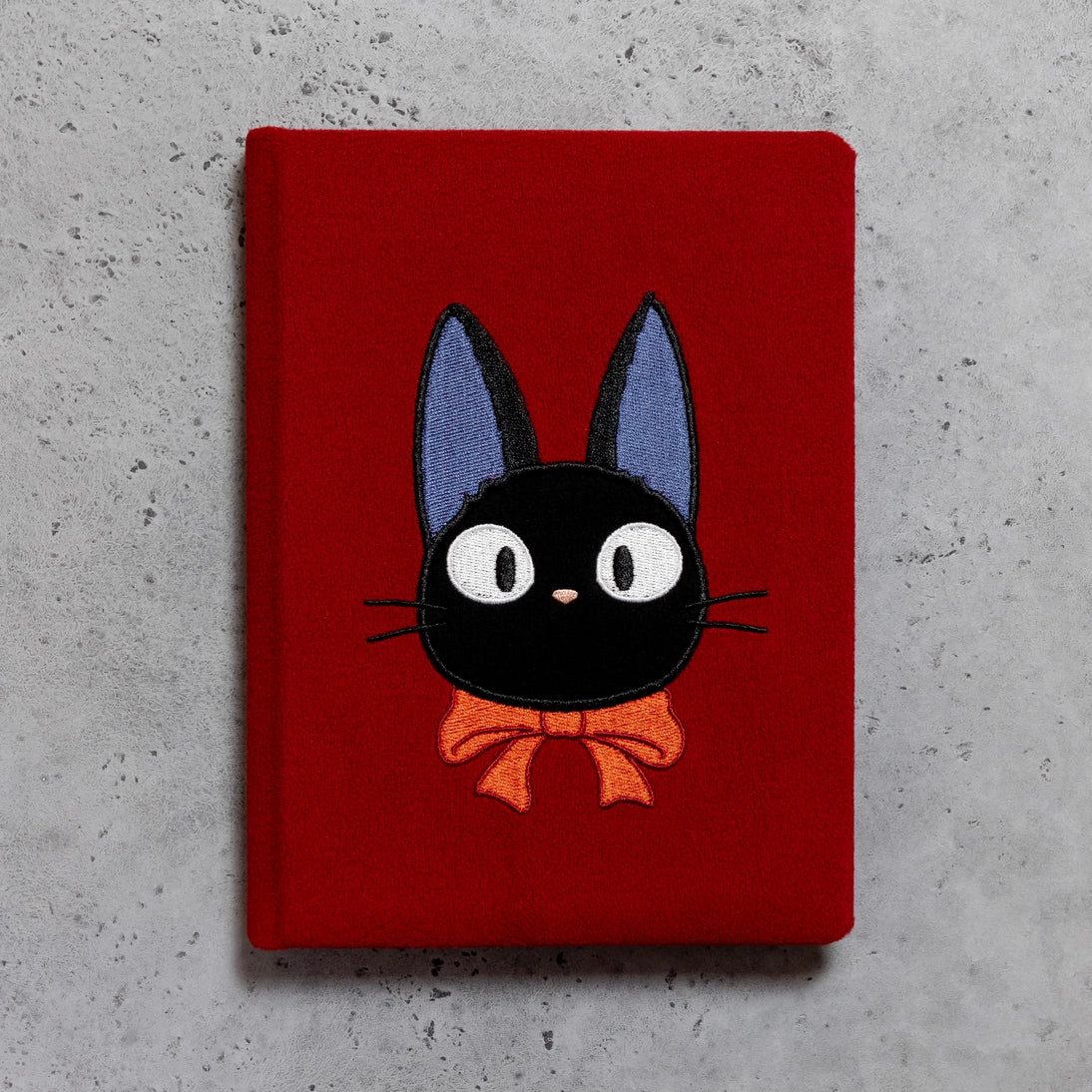 Red plush journal back cover with centered Jiji black cat face