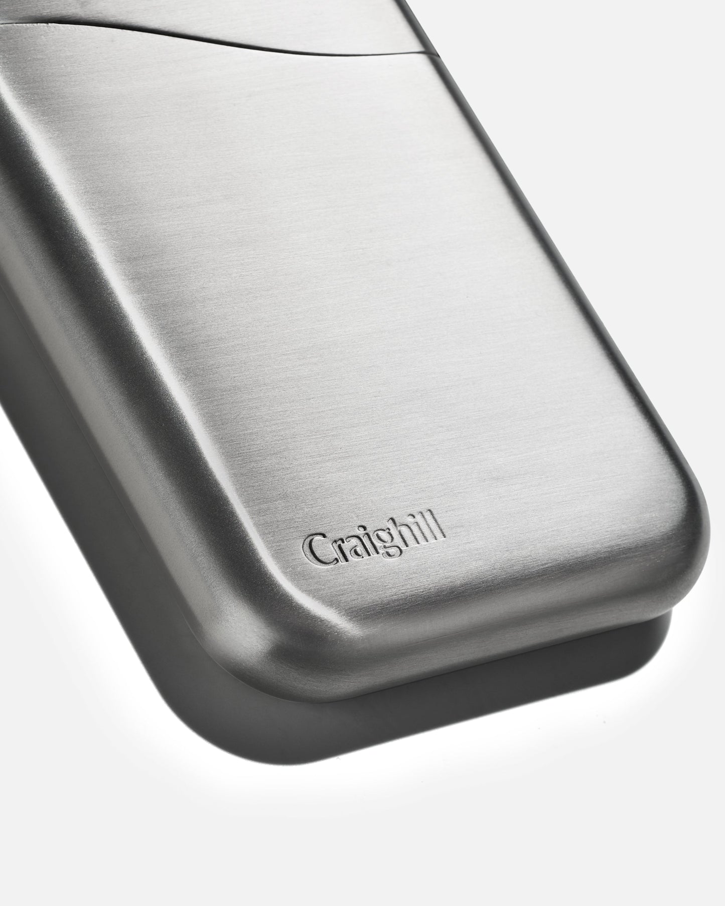 Craighill stainless steel card case close-up with embossed logo on smooth curved surface.