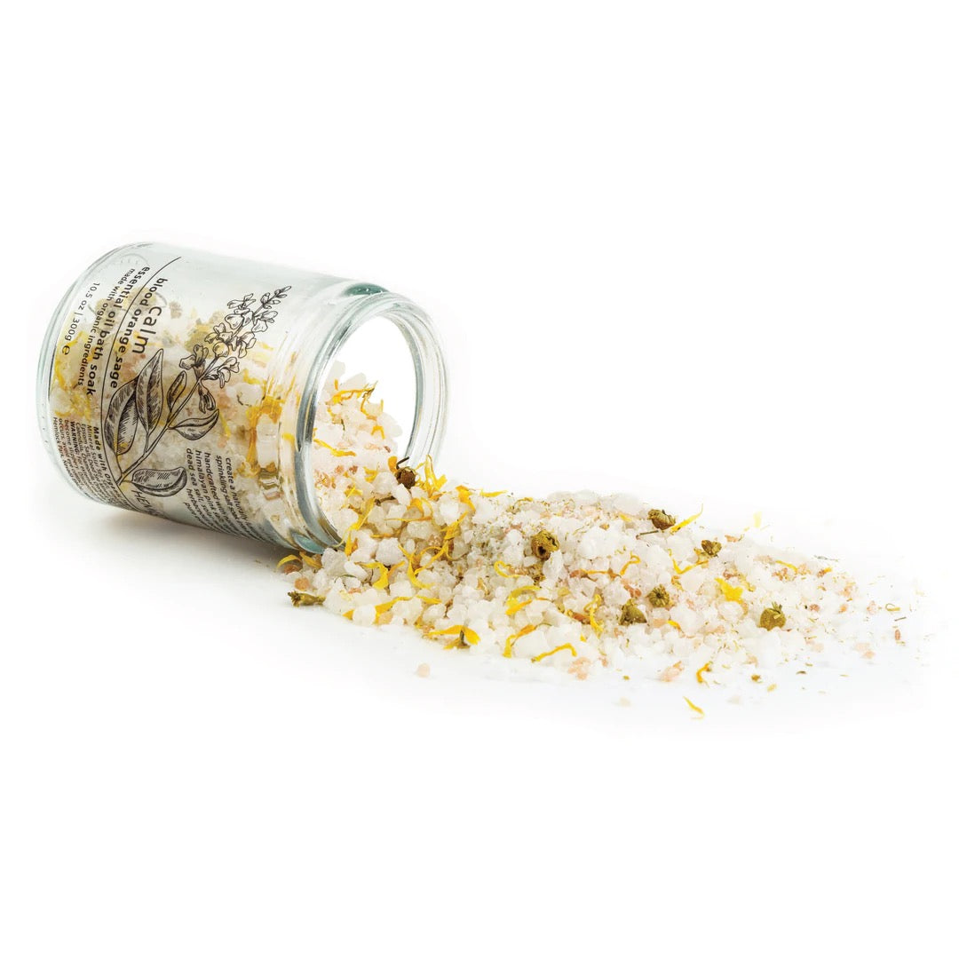 Essential oil bath soak with yellow crystal flakes spilling from jar
