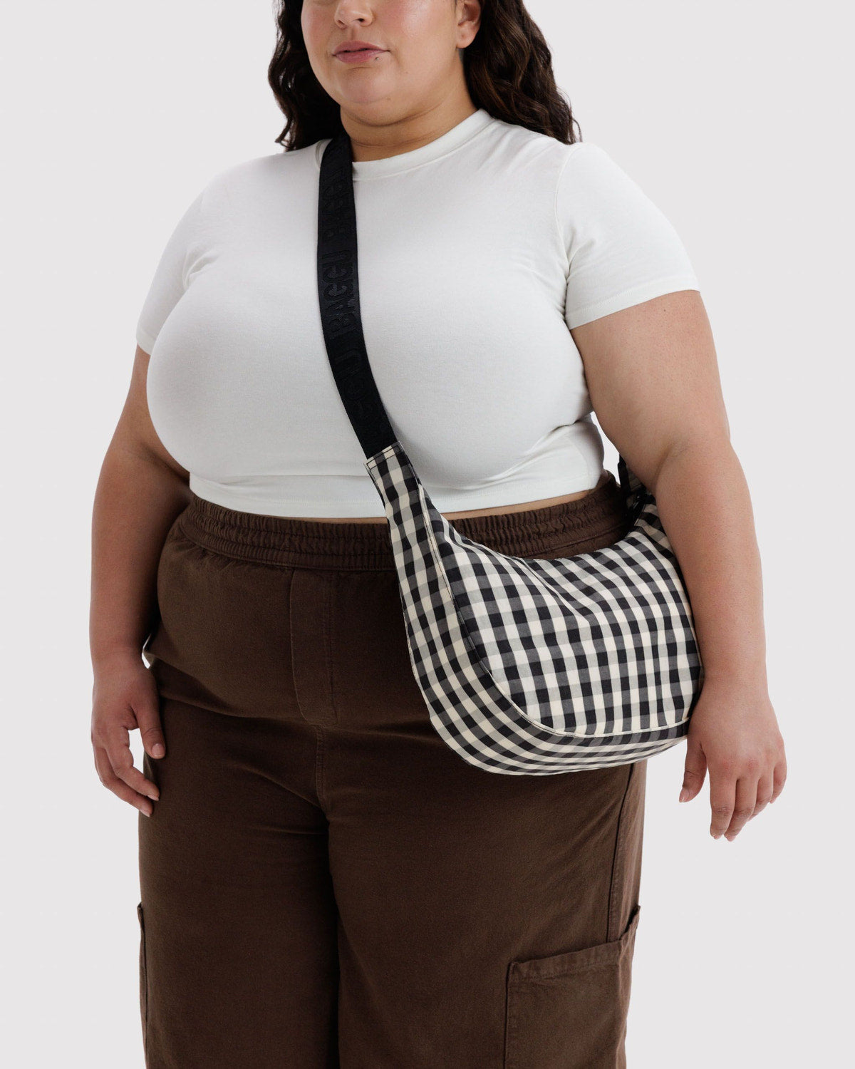 Medium crescent nylon bag, black-and-cream gingham, worn crossbody