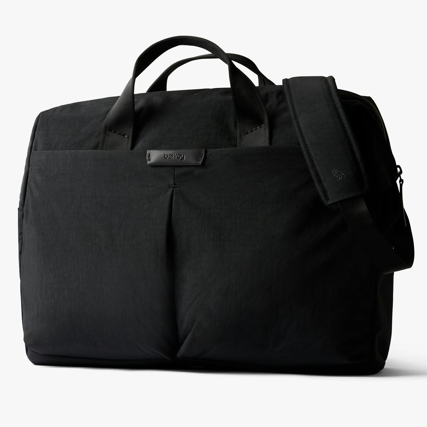 Black work bag with top handles, front pocket, and adjustable side strap