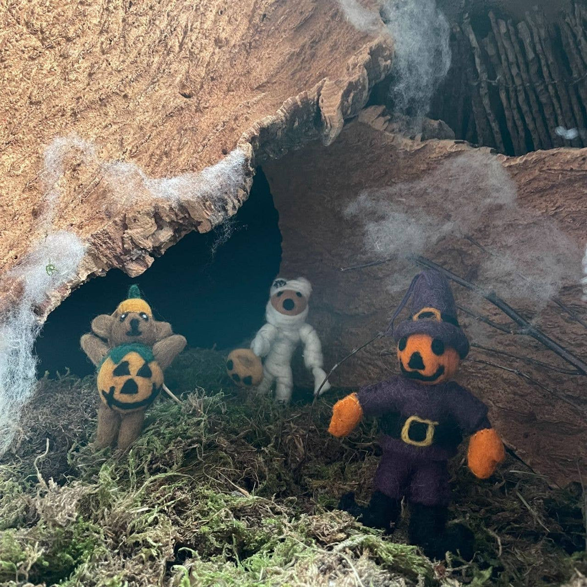 Felt fox mummy hanging decorations in a Halloween scene with pumpkin heads and hay