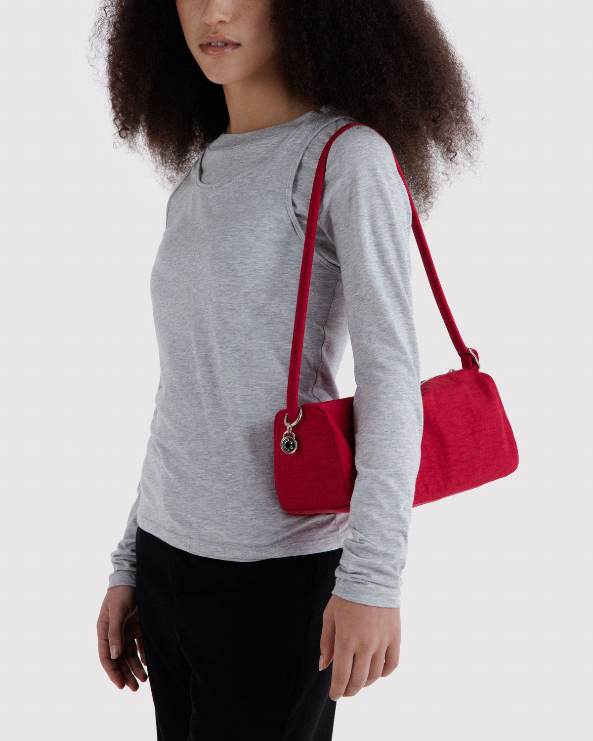 Red nylon loaf bag worn crossbody with zip-top and adjustable strap