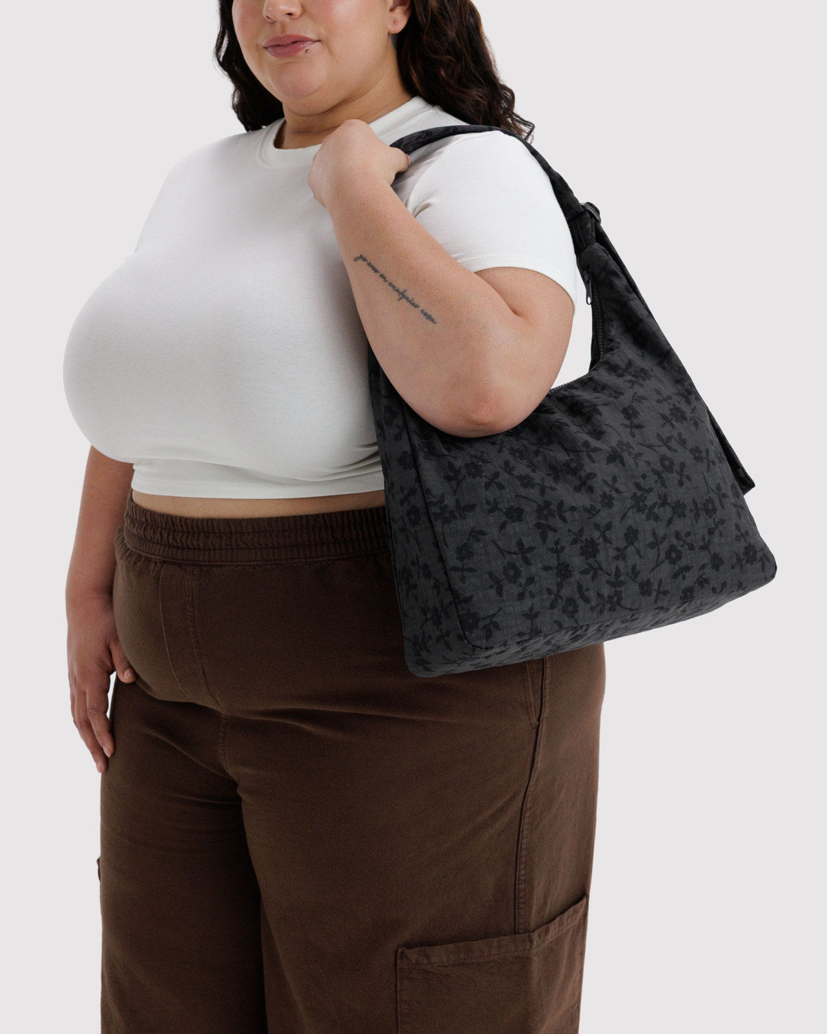 Nylon shoulder bag in dark gray with subtle pattern and top handle with zip opening.