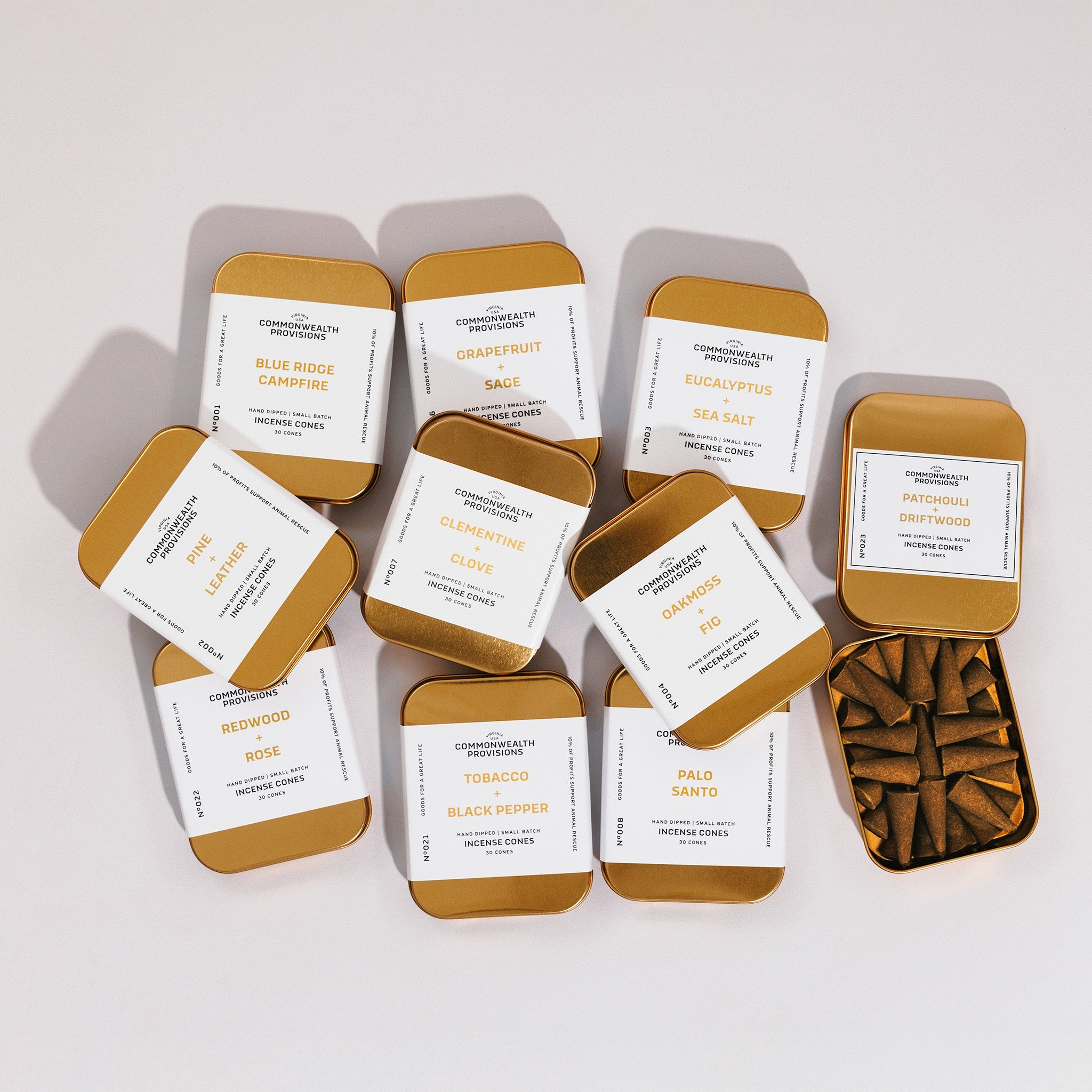 Assorted hand-dipped incense cone tins with labels and an open tin of cones