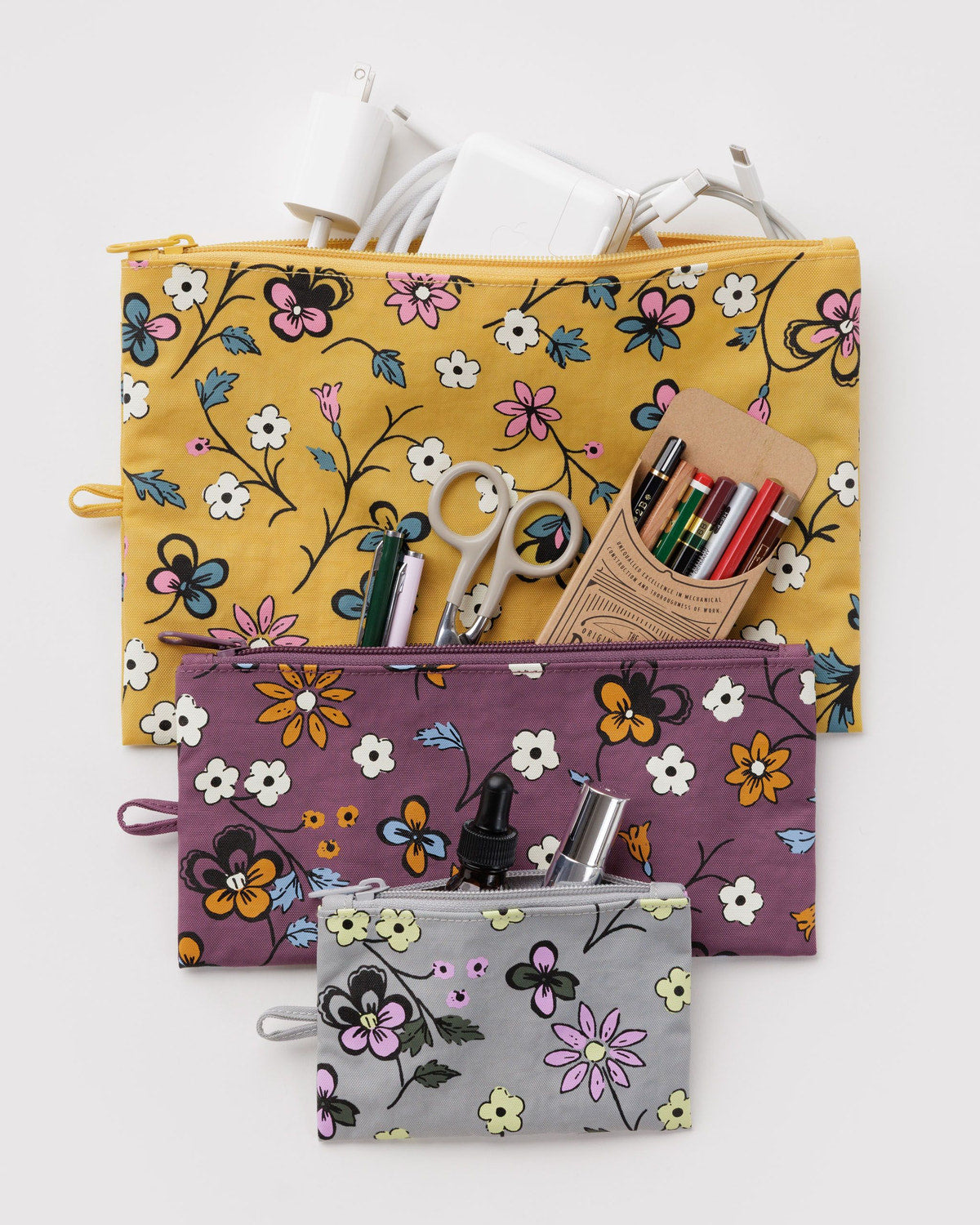Set of three flat zip pouches with floral prints in yellow and purple