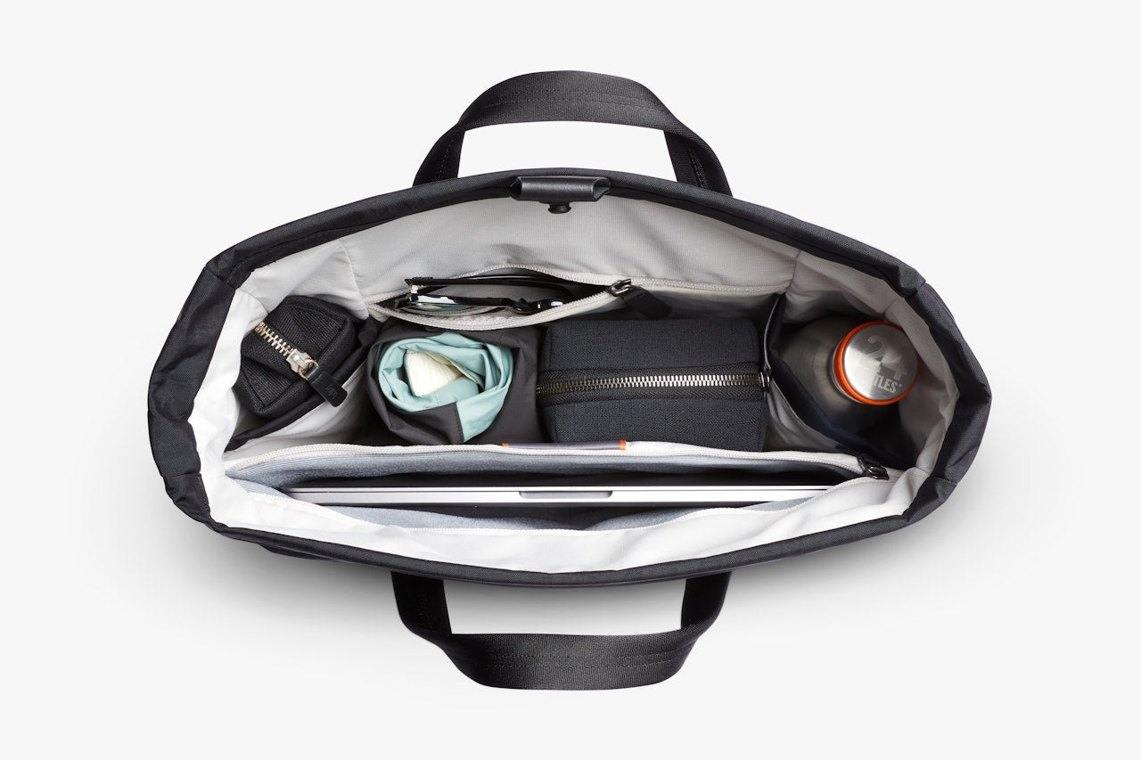 Open black messenger bag interior with zip pocket and organizer compartments.