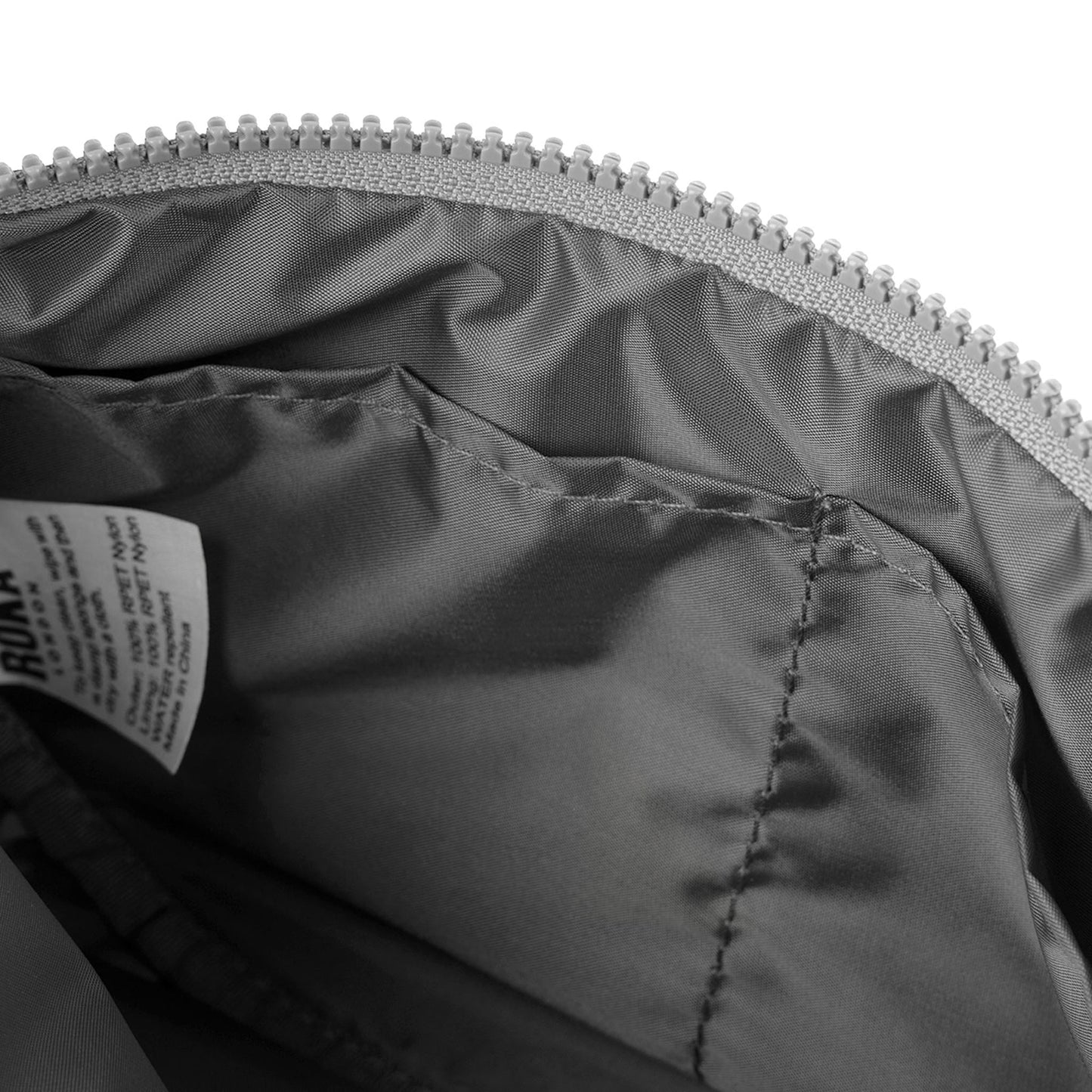 Half-moon bag interior lining with dark fabric and stitched zip channel.