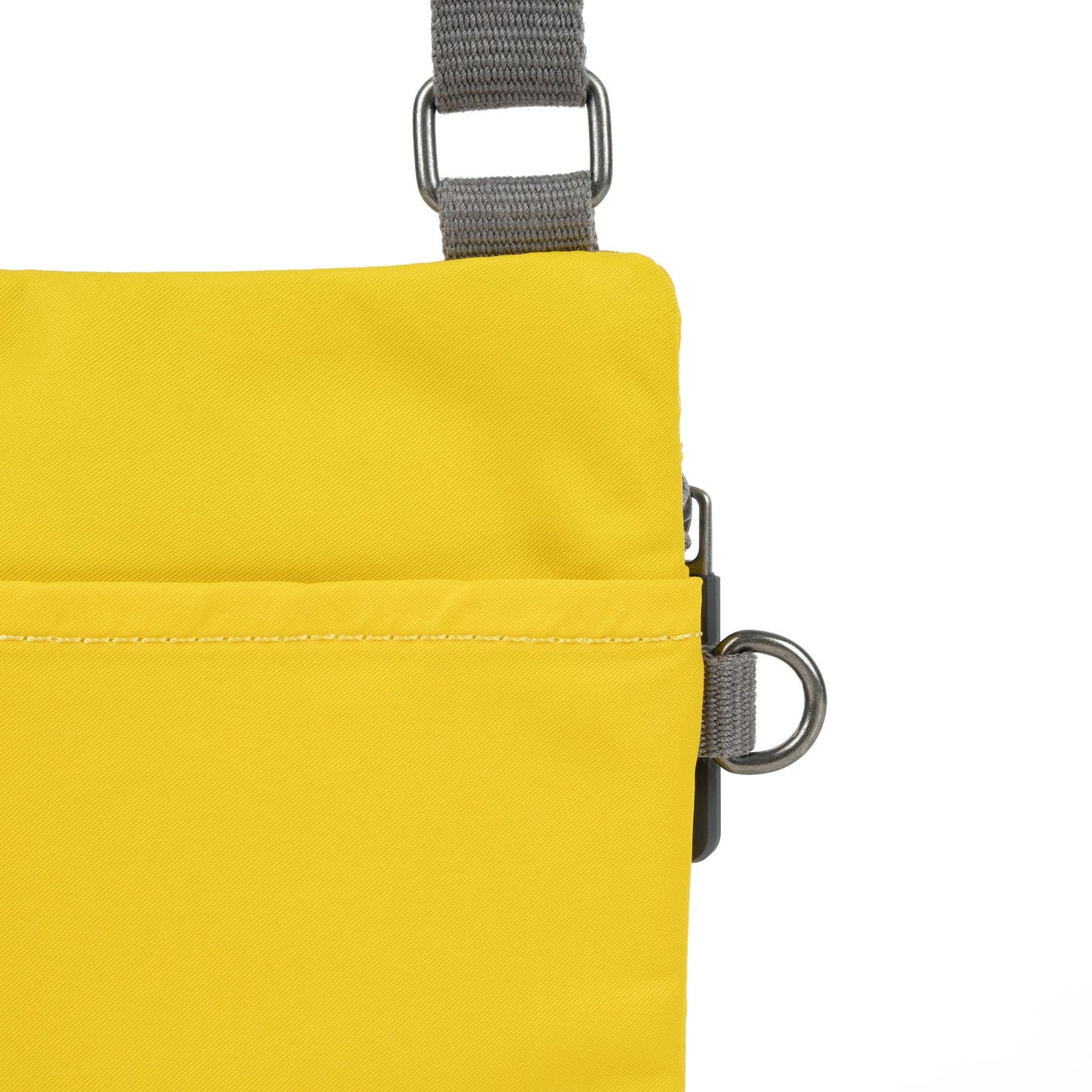 Yellow nylon crossbody close-up with front seam, zipper, and metal D-ring
