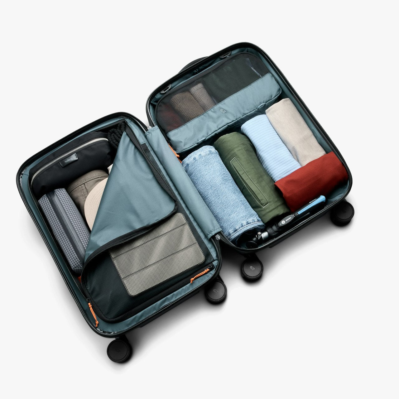 Open black carry-on suitcase with interior compartments, straps, and packed clothing
