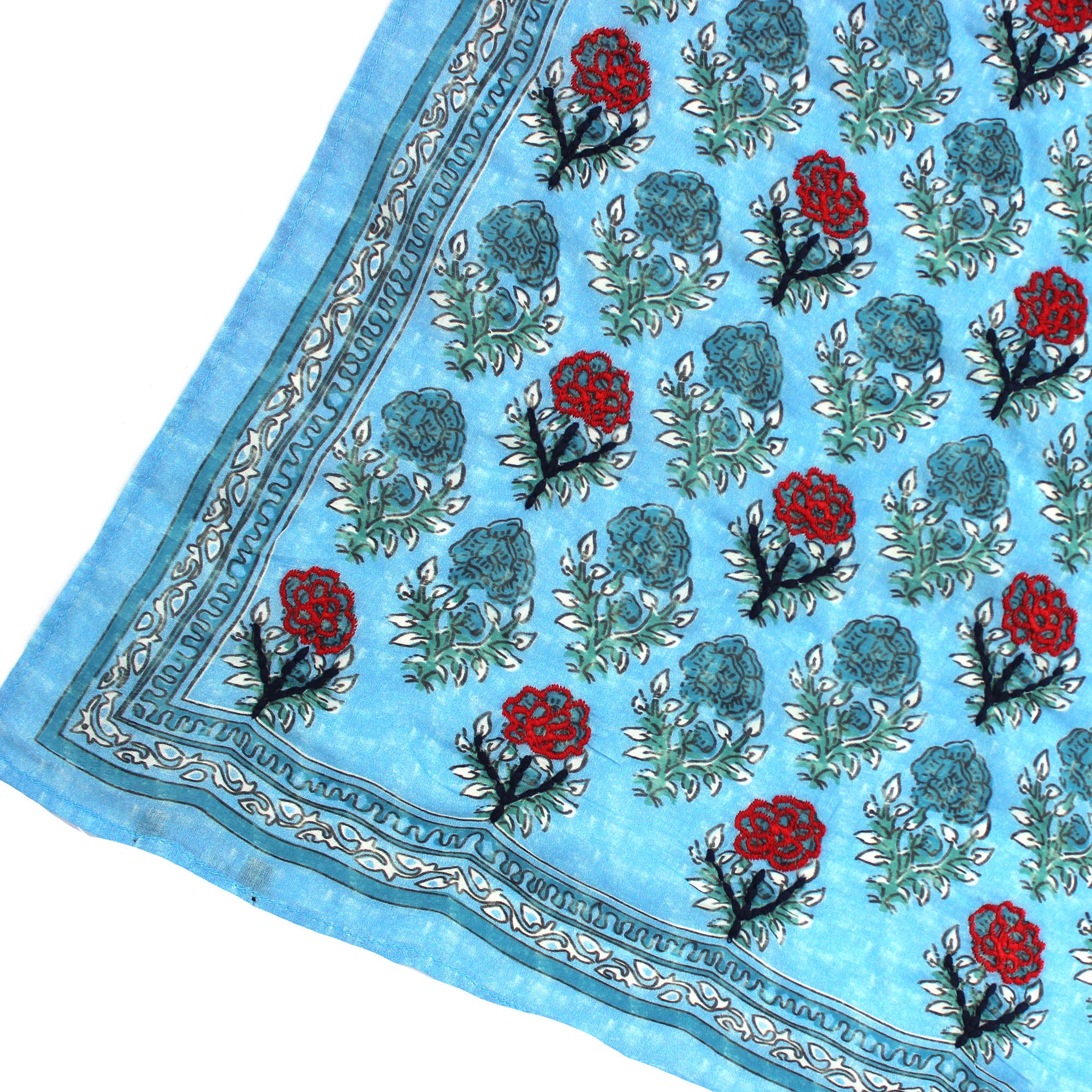Corner view of blue floral bandana with red roses, teal blooms, and decorative trim