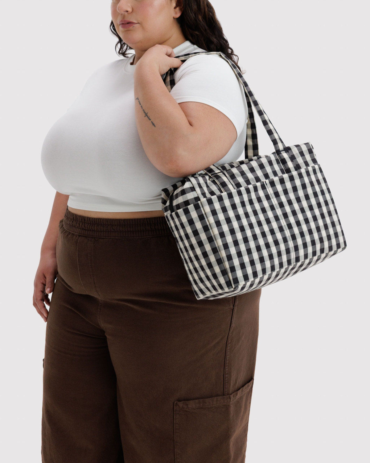 Black and white gingham tote bag worn on shoulder with structured sides
