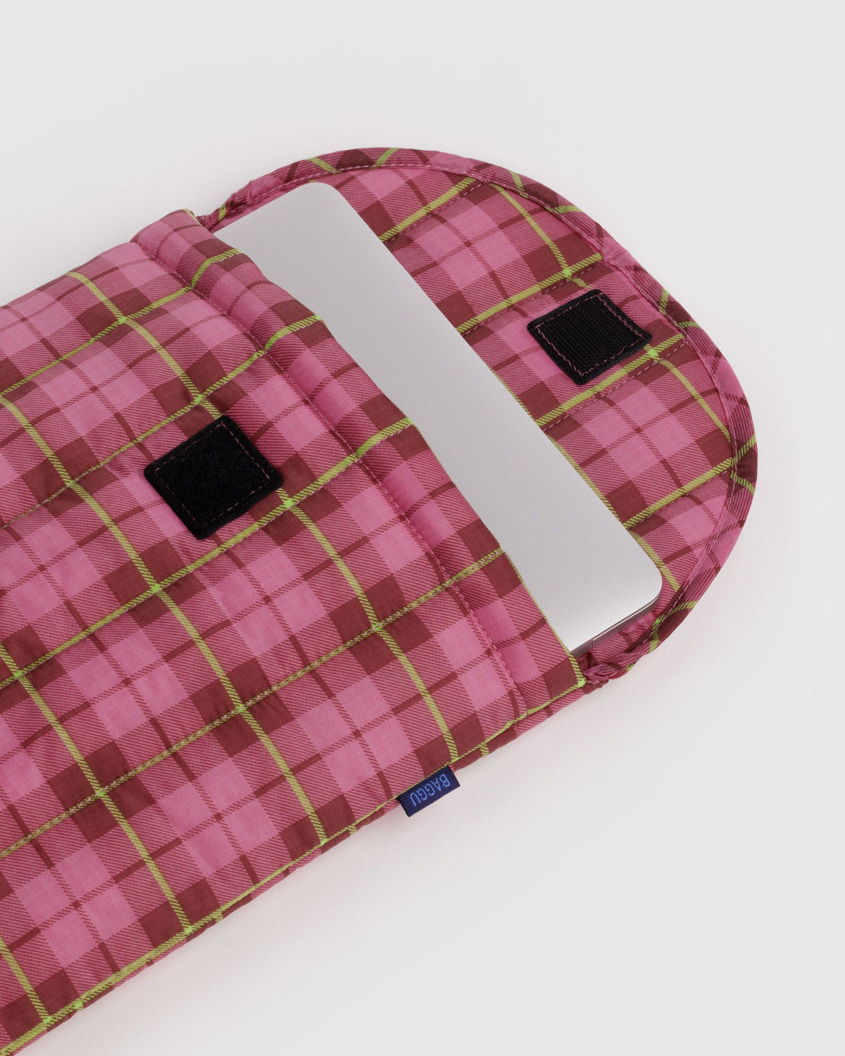 Pink plaid puffy 13"/14" laptop sleeve with quilted top flap and black label tabs.