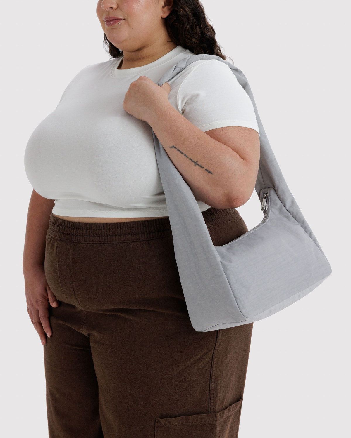 Light gray nylon meringue bag worn on shoulder, slouchy roomy shape