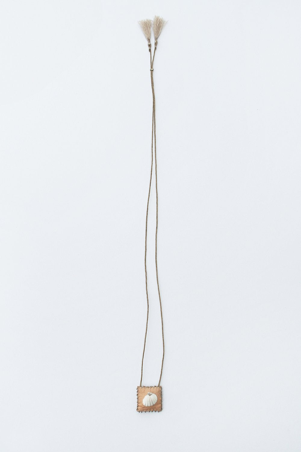 Small square seashell talisman pendant on long thin gold cord necklace