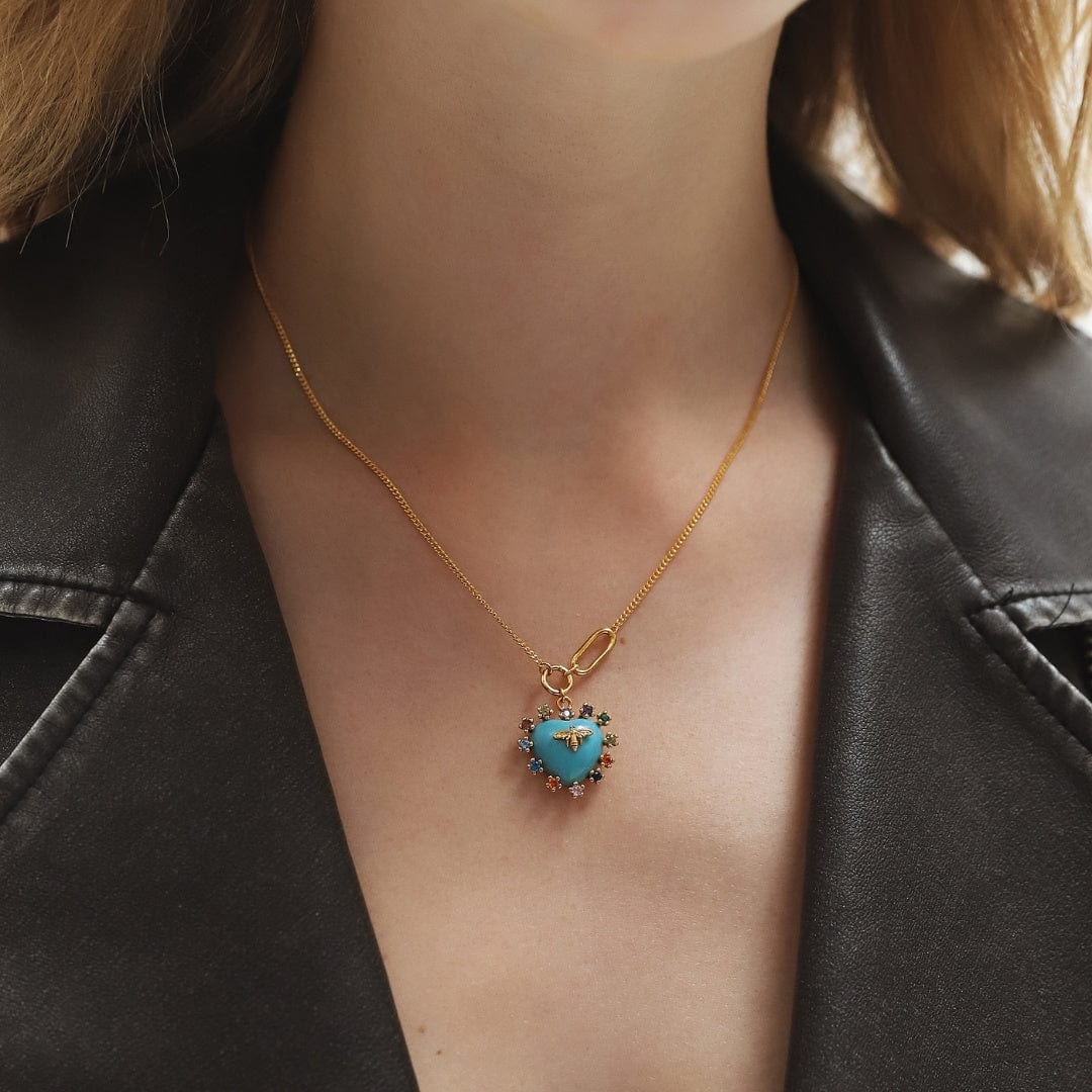 Gold heart pendant necklace with turquoise bee charm centered on neckline
