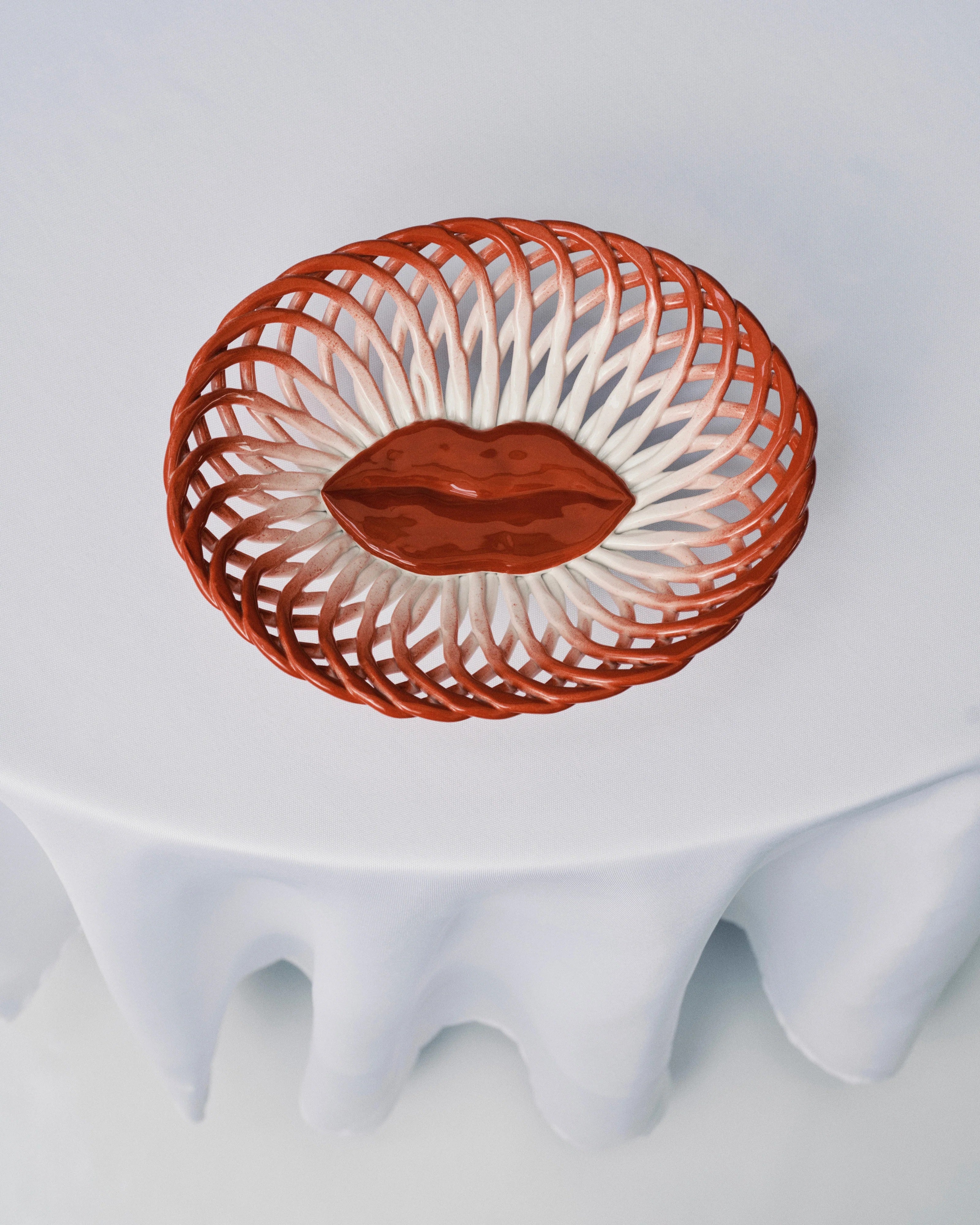 Red woven earthenware bread basket with scalloped rim and reddish glazed center