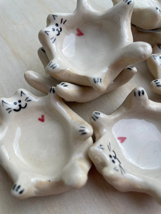 White ceramic cat ring dishes with painted whiskers, paws, and red heart accents.