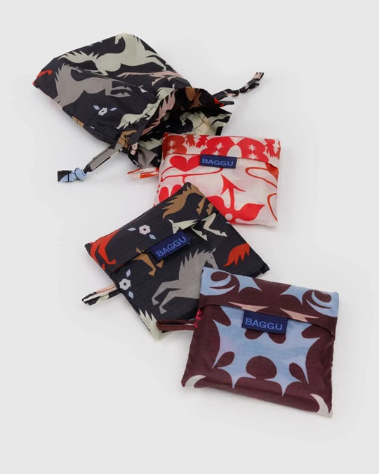 Three drawstring pouches with dark animal, red floral, and brown patterns