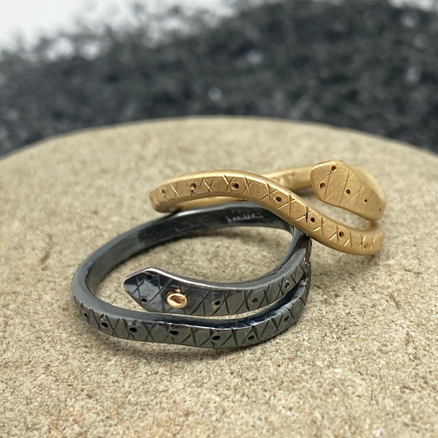 Snake ring with engraved symbols, matte brass and dark band close-up