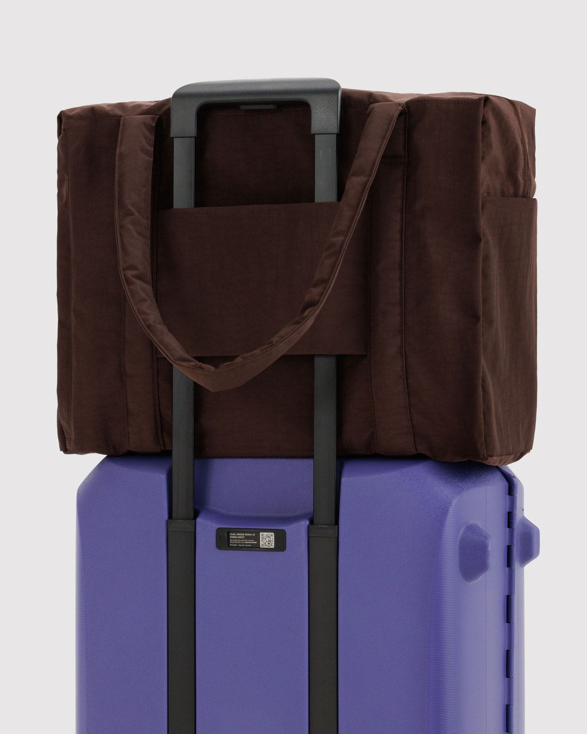 Carry-on bag in dark brown with front pocket and adjustable shoulder strap