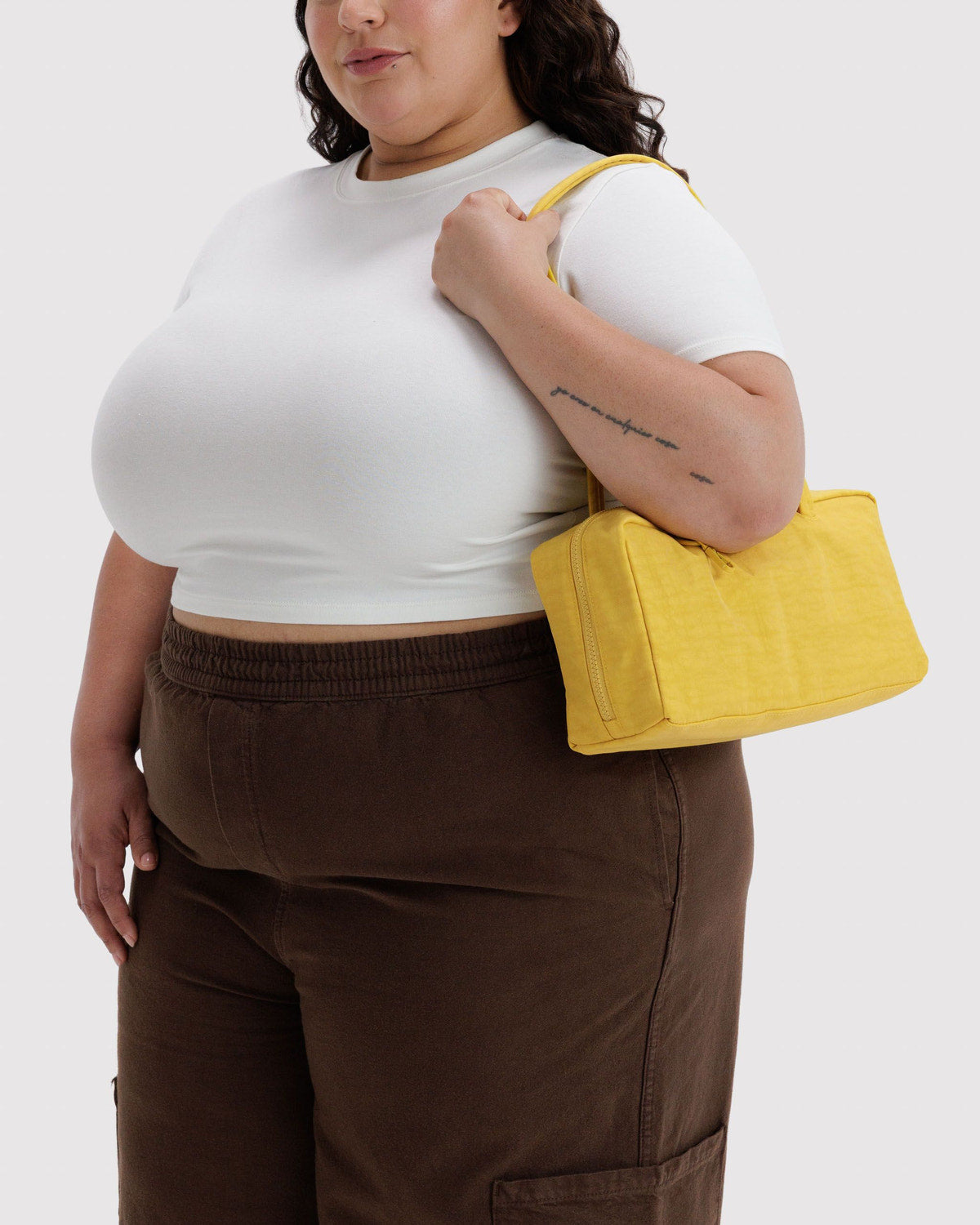 Butter yellow nylon bowler bag with short top handles and zippered opening