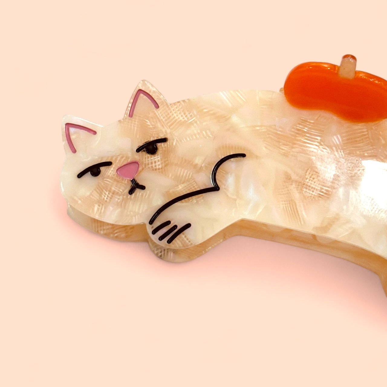 Cream cat hair claw with orange top clip and side view of cartoon kitty face