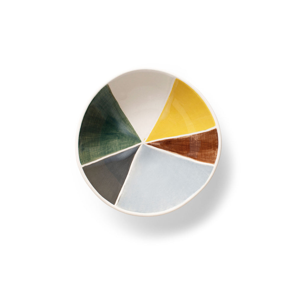 Round ceramic dish with multicolor wedge pattern—yellow, green, white, and brown interior.