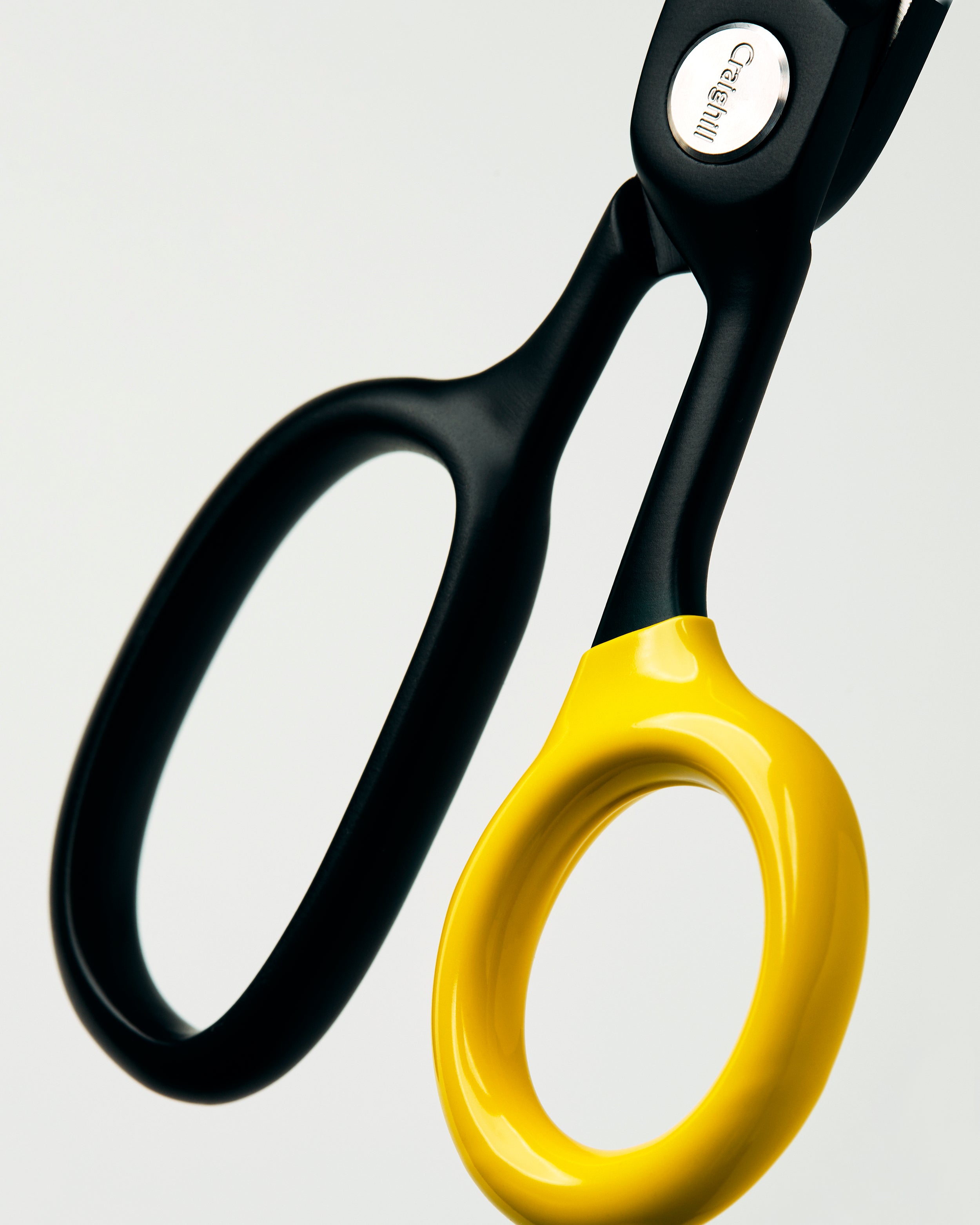 Black scissors close-up with glossy yellow finger loop handles