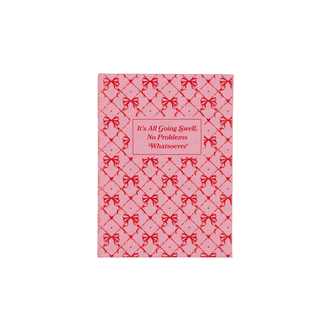 Pink notepad with red bow pattern and quote: "It's All Going Swell, No Problems"