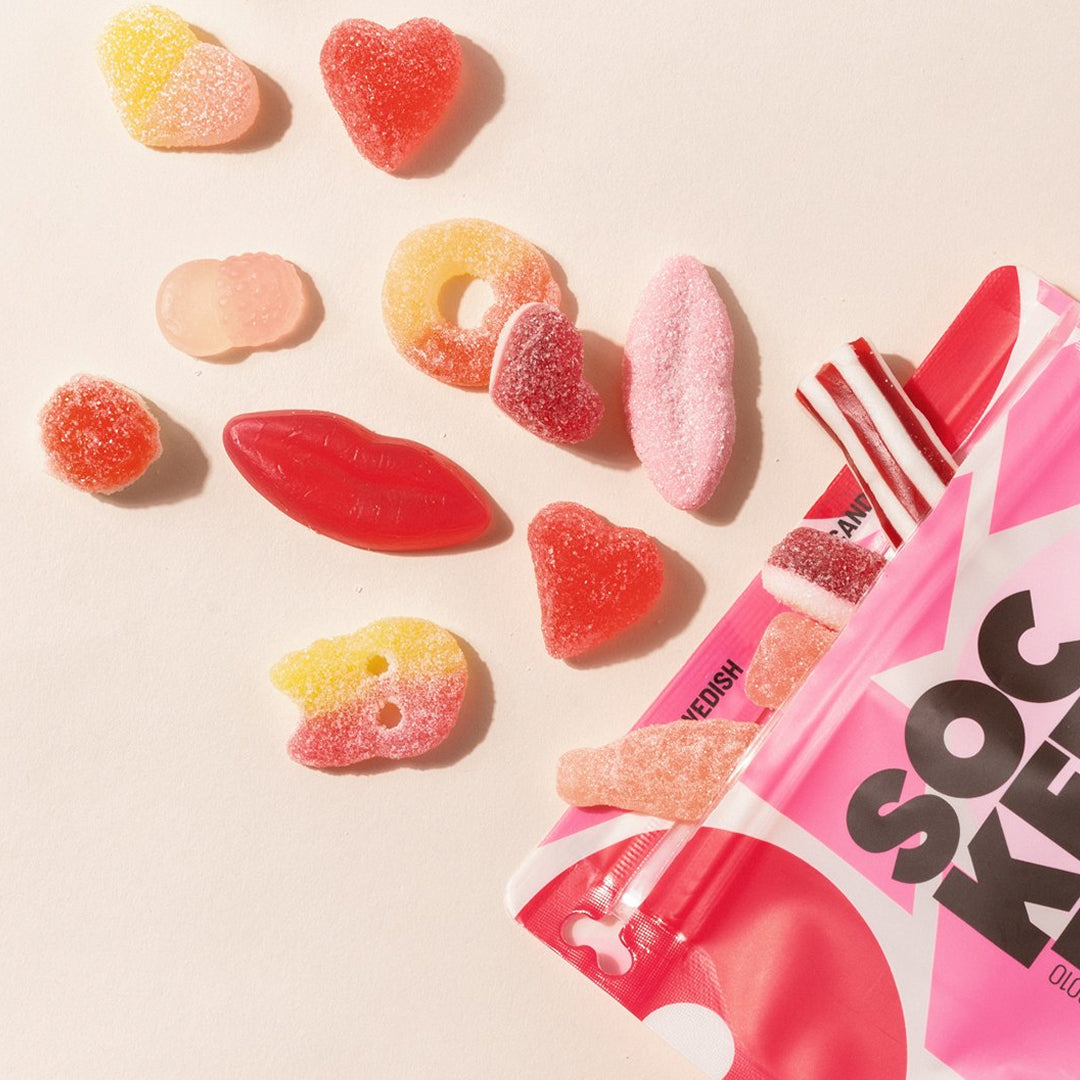 Heart and berry-shaped gummy candies near a pink SocKerBit mix pouch