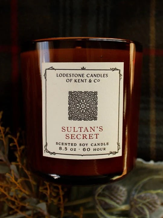 Soy candle in amber glass jar with cream label and Sultan’s Secret branding