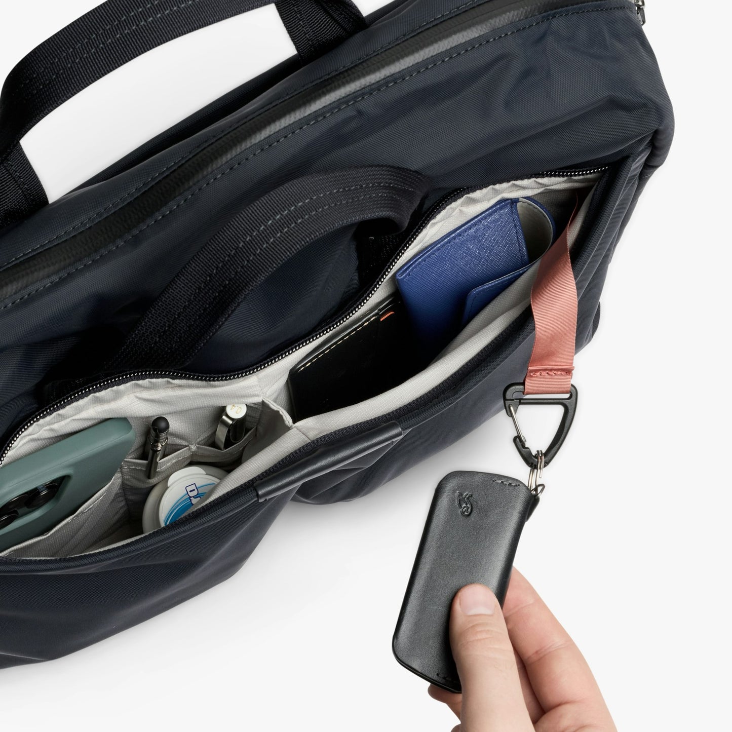Navy work bag interior with zip pocket, elastic organizer, and key fob attachment
