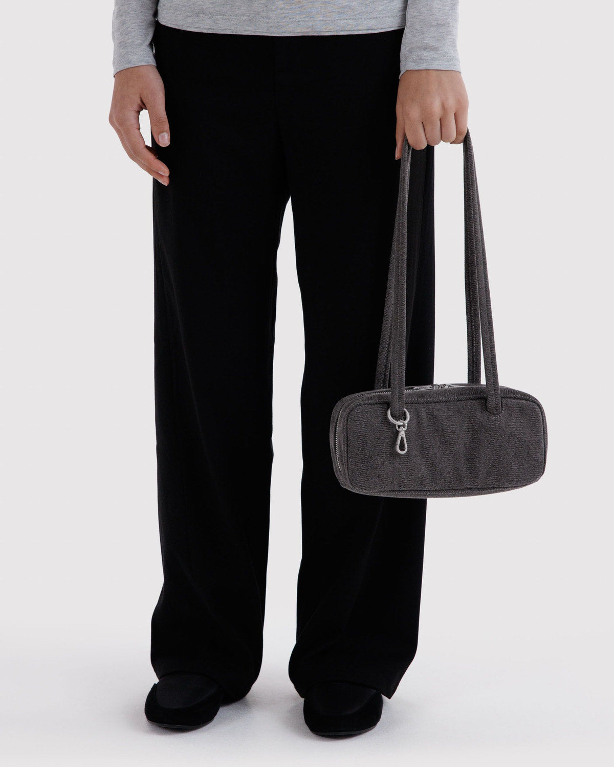 Washed black denim bowler bag with two top handles, carried at side