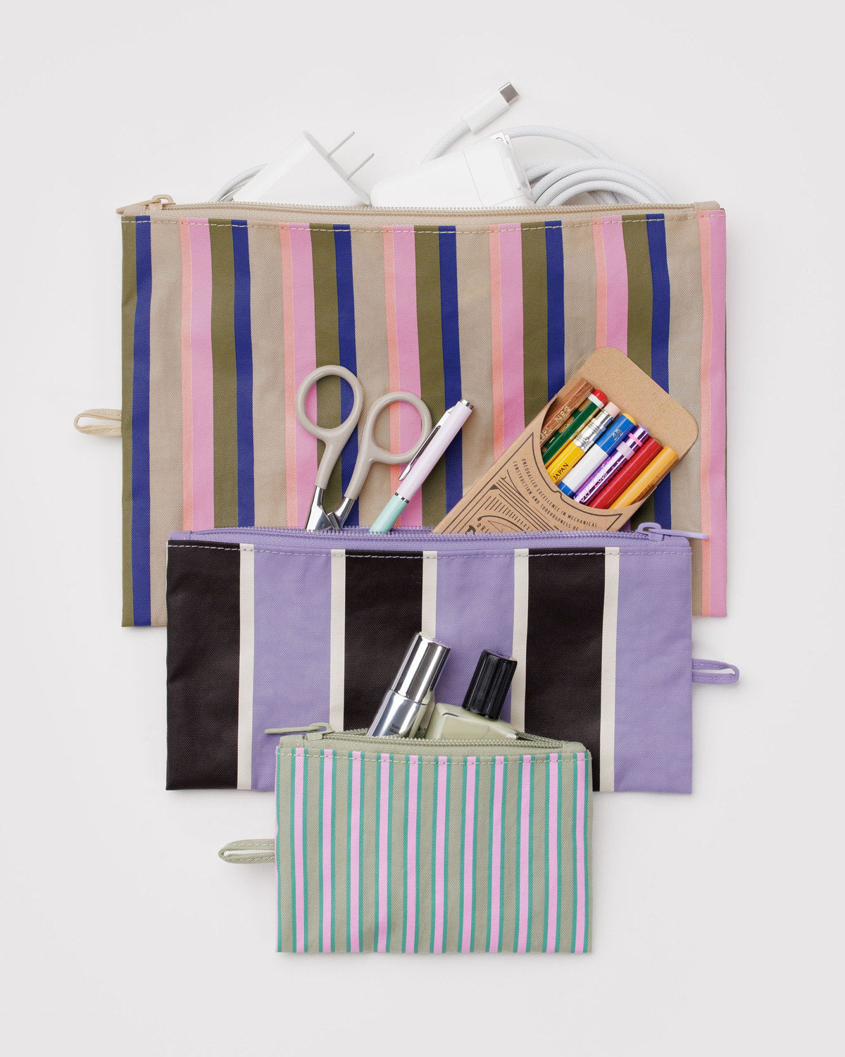Set of three flat zipper pouches with pastel vertical striped prints and rainbow accents