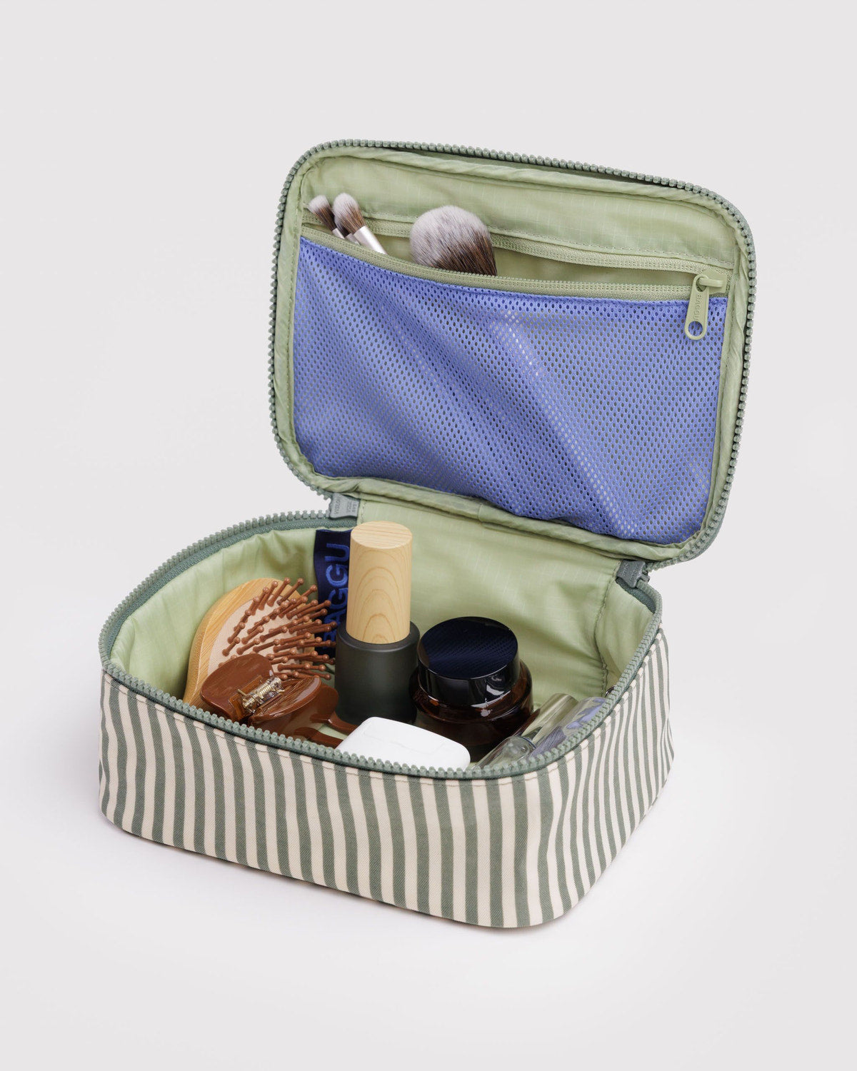 Small cosmetic case, open green striped interior with blue mesh pocket and toiletries