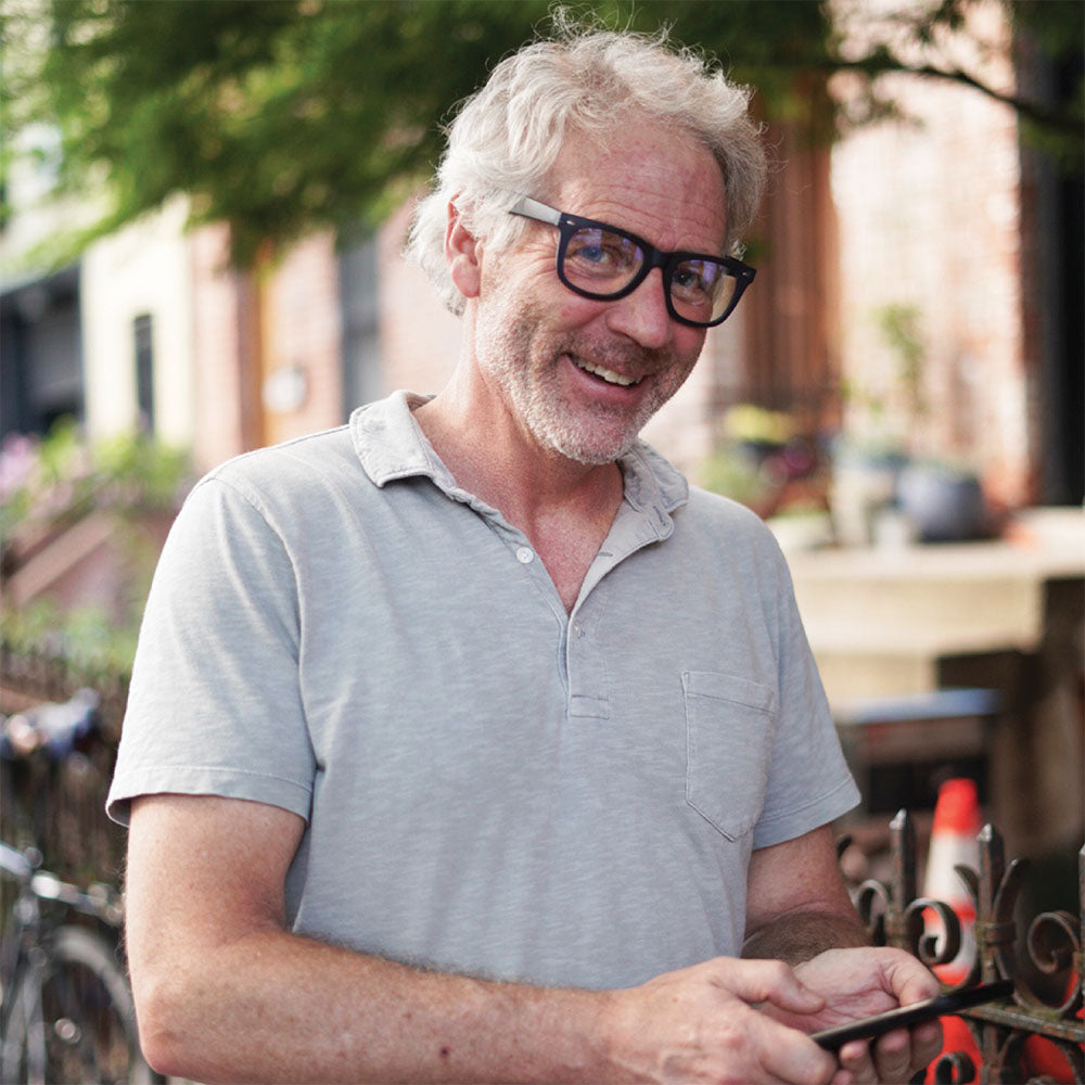 Black eyeglasses on a man with gray hair, rounded rectangle frame
