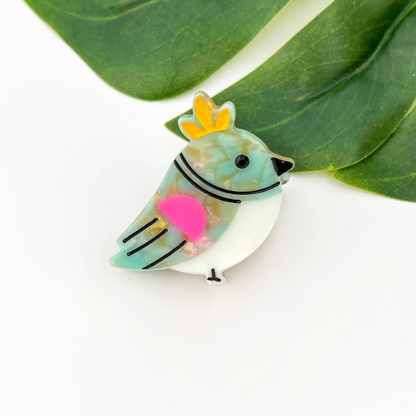 Translucent mint bird hair claw clip with yellow crown and pink heart detail