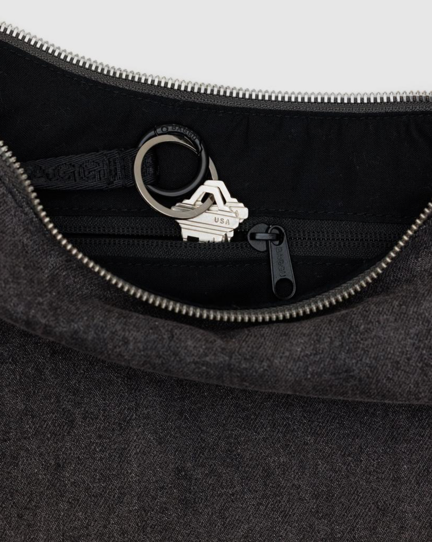 Denim crescent bag interior with silver zipper, logo snap ring, and key clip