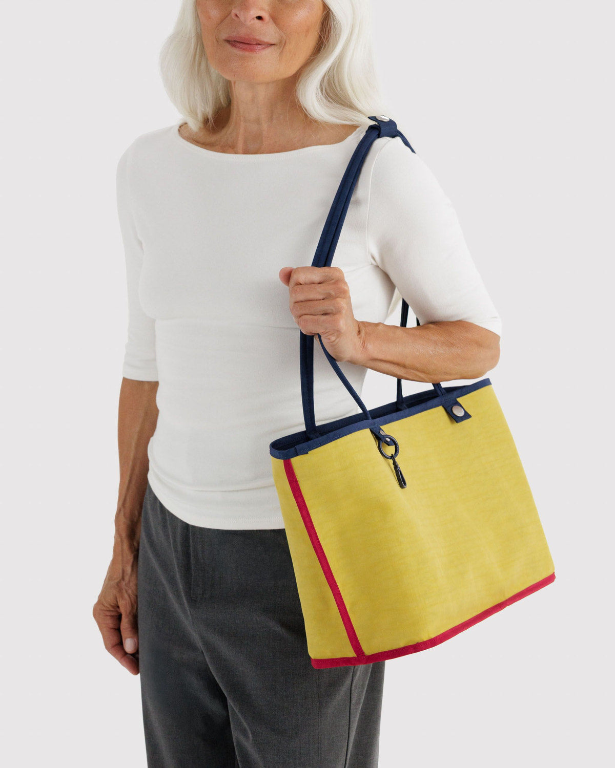 Medium reversible nylon tote with top handles and zip closure, navy with yellow side panel.