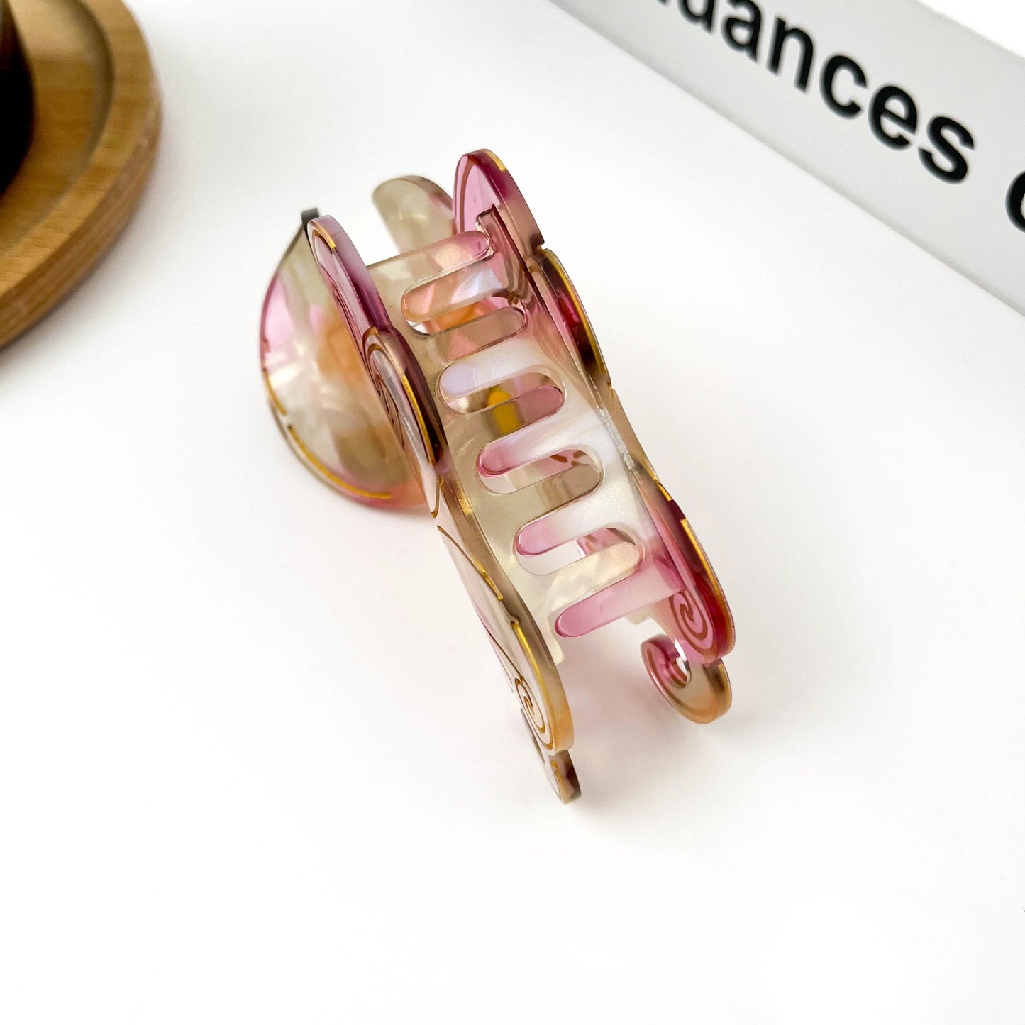 Octopus claw hair clip open view with translucent pink interior and gold-toned hinge