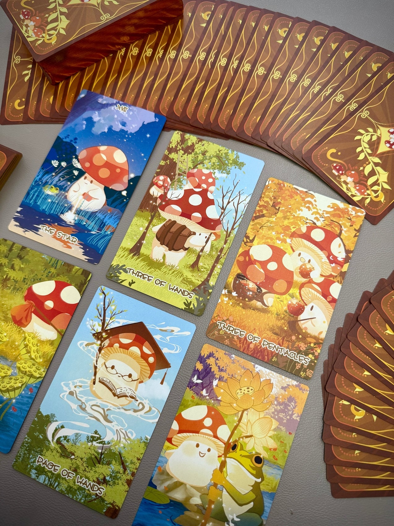 Tarot cards spread out in rows with mushroom character scenes and decorative backs