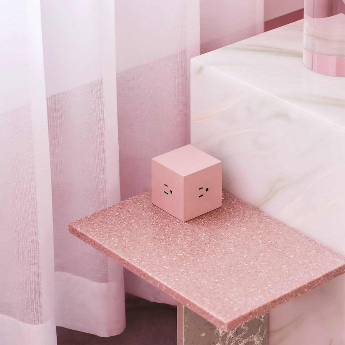 Square 1 extension cord cube in blush pink with outlets on a countertop