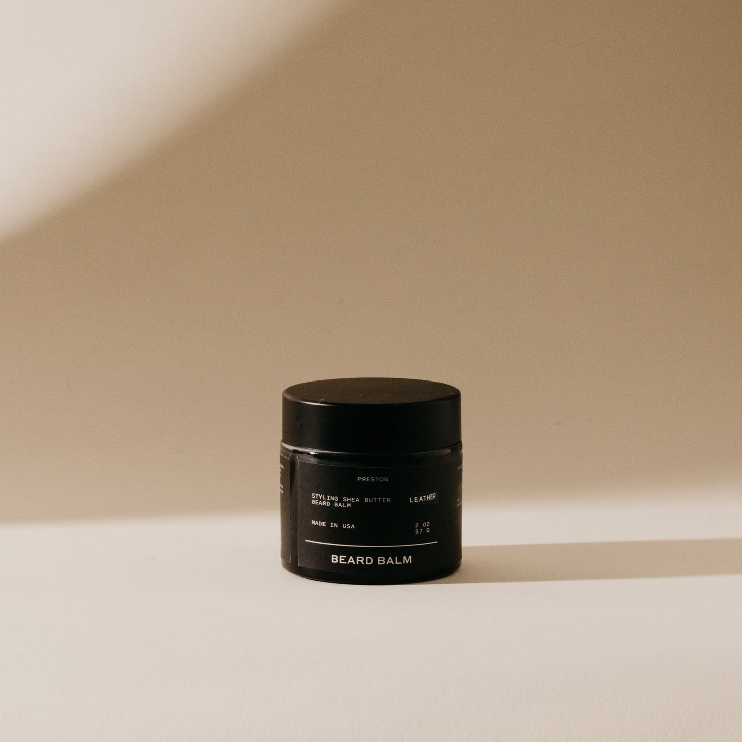 Beard balm jar, black container with gold label and screw-top lid